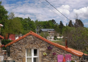 Acceso principal con fachada en piedra y patio con mesa y sillas