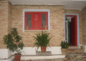 Acceso principal a la vivienda con ventana roja