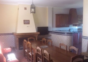 Cocina con mesa auxiliar y armarios de madera