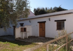 Acceso a la casa con la barbacoa y jardines