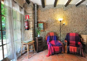 Sala de estar y paredes de piedra con una mesa de madera