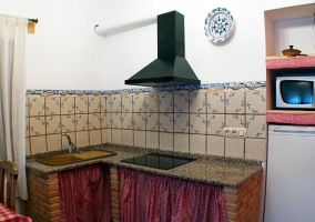 Cocina de la casa en L con detalles en rojo