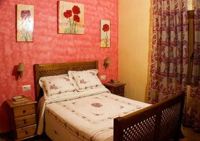 Dormitorio de matrimonio con estructura de madera y ventanal