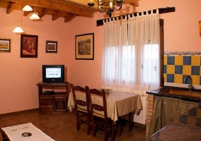 Sala de estar con televisor y mesa de madera