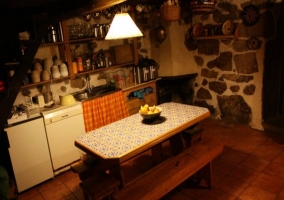 Cocina con menaje y mesa de madera