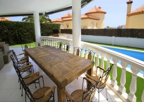 Mesa de madera junto a la piscina