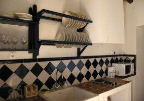 Cocina con azulejos blancos y negros y microondas