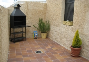 Patio interior de la casa con barbacoa en la esquina y plantas