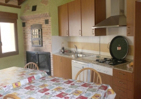 Cocina con horno tradicional y mesa en el centro