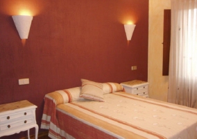 Dormitorio con cama matrimonial y pintura de la pared roja