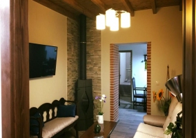 Sala de estar con la chimenea en una esquina y la tele