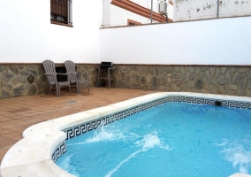 Sala de estar con la mesa de madera y sus sillas