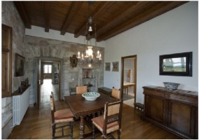 Amplio comedor con mesa grande de madera con una decoración clásica y un tanto señorial