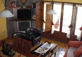 Sala de estar con zona de comedor y la chimenea que hace esquina