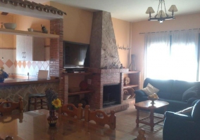 Sala de estar con la mesa de madera y la chimenea