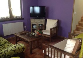 Sala de estar con paredes moradas y sillones