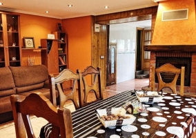 Sala de estar con mesa y chimenea en el centro