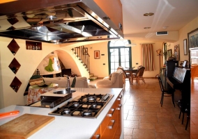 Sala de estar con chimenea y la cocina al fondo