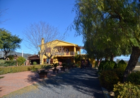 Acceso a la casa con la fachada amarilla
