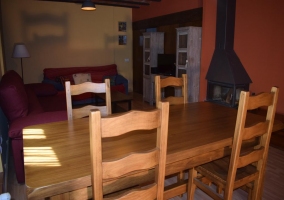 Sala de estar con mesa de madera y la chimenea