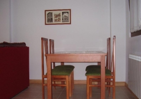 Sala de estar con mesa de cristal y sillones rojos