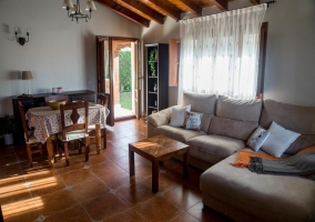 Sala de estar con mesa y mueble con la tele de plasma