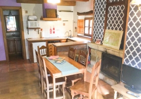 Sala de estar con chimenea y mesa delante