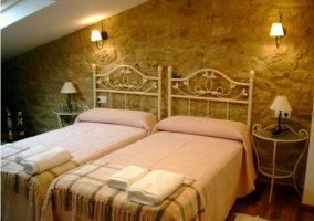 Dormitorio matrimonial de la casa rural con paredes de piedra y armario