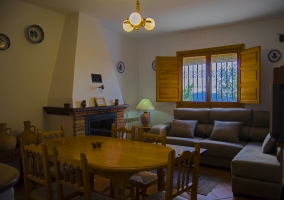 Sala de estar con mesa de comedor y la chimenea delante