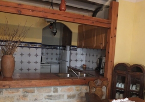 Comedor con mesa de madera y vista de la cocina