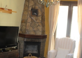 Sala de estar con la chimenea en piedra