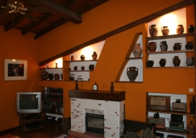 Sala de estar con la chimenea junto a la tele y detalles