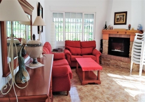 Sala de estar con chimenea y sillones rojos