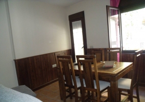 Sala de estar y zona de comedor con mesa de madera