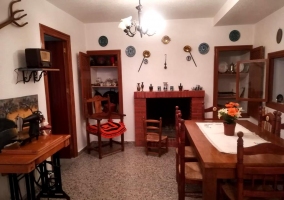 Sala de estar con la chimenea y la mesa de madera con sillas