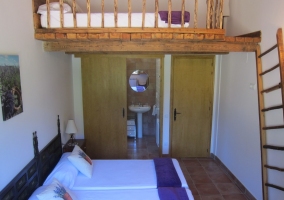 Dormitorio con cama en buhardilla.