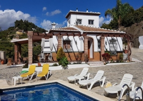 Acceso  a la casa con piscina y la fachada en blanco