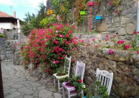 Amplios exteriores con flores y sillas blancas