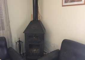 Sala de estar con la chimenea y la ventana a un lado