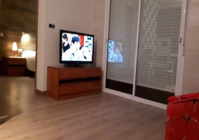 Sala de estar junto a la cocina con tele de plasma