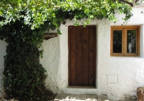 Acceso a la casa con puerta de madera y ventanas