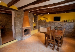 Comedor de la casa rural con televisión y chimenea