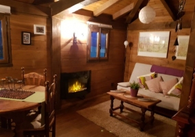 Sala de estar con chimenea y mesa al fondo para comer