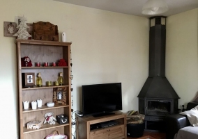 Sala de estar con chimenea en forja y tele