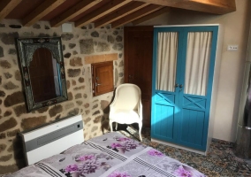 Habitación con cama de matrimonio y paredes de piedra