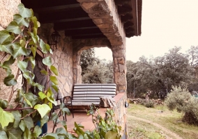 Amplio porche de la casa con plantas y banco