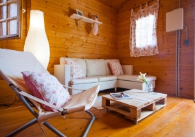 Sala de estar y zona de comedor con paredes de madera