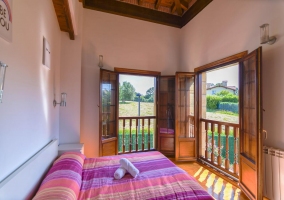 Habitación con cama de matrimonio y balcones