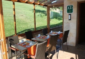 Porche en entorno muy soleado con varias mesas para comer en la mejor atmósfera