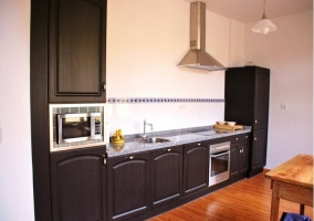 Cocina de madera oscura con electrodomésticos